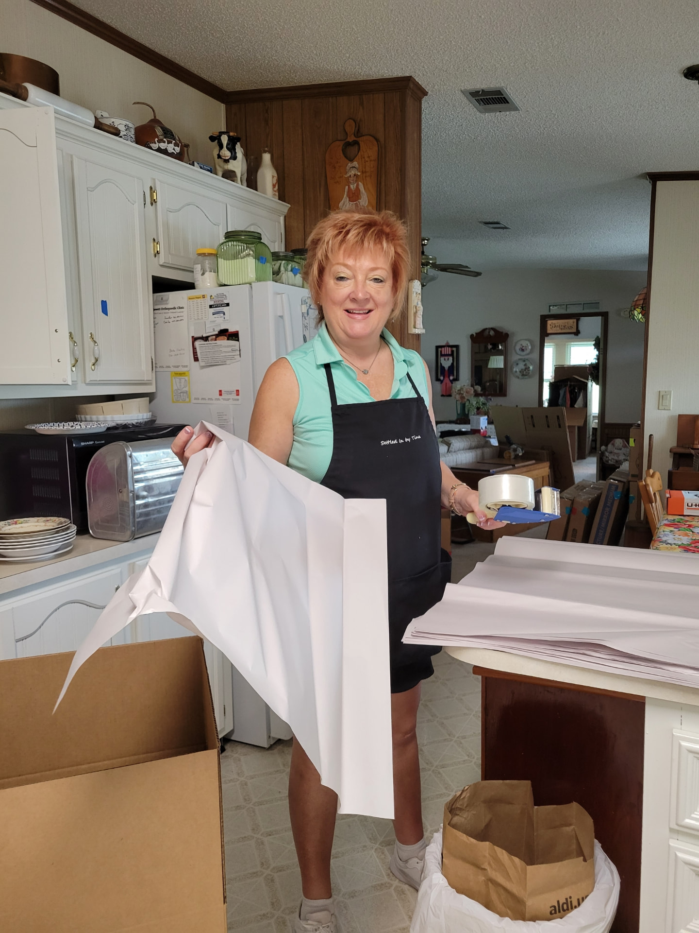 Tina wrapping kitchenware at a client's home